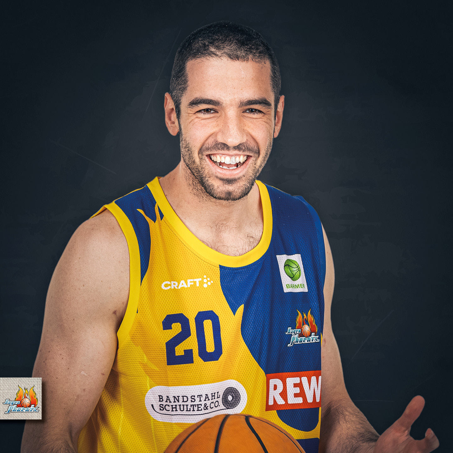 Ein lächelnder Basketballspieler im gelben Trikot, hält einen Ball in der Hand.