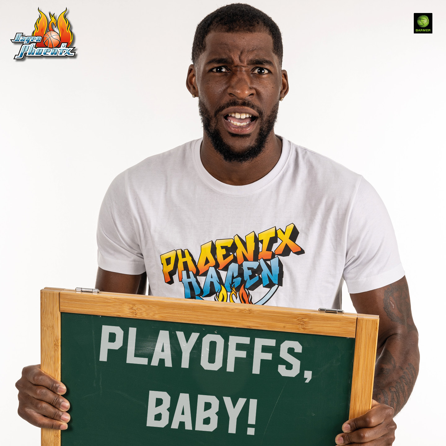 Mann mit Bart schaut überrascht, hält Tafel mit "PLAYOFFS, BABY!", trägt weißes T-Shirt.