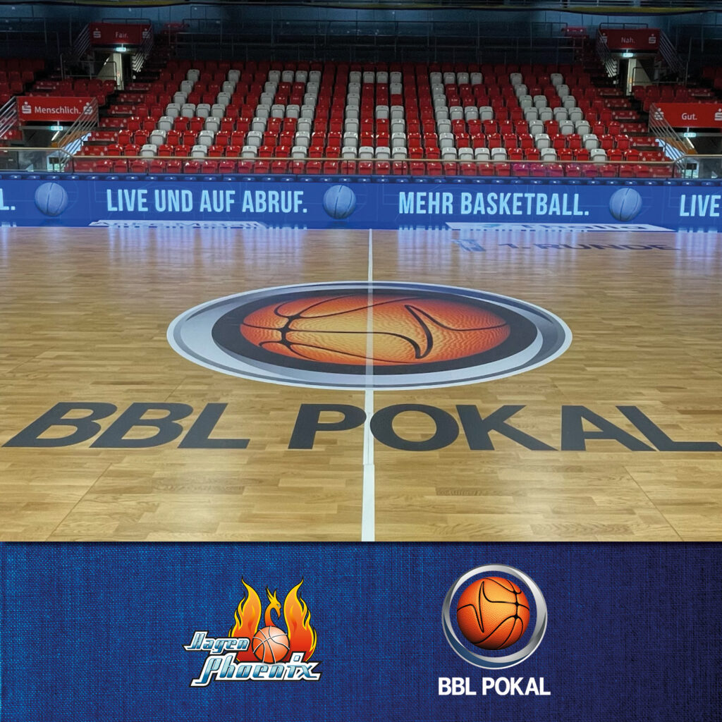 Basketballfeld mit "BBL POKAL"-Logo in der Mitte, rote Sitzreihen mit "HAGEN"-Schriftzug im Hintergrund.