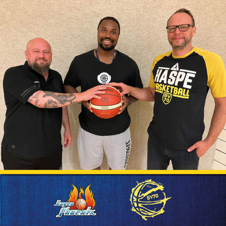 Drei Männer lächeln, halten Basketball; tragen Freizeitkleidung, Tattoos sichtbar; Sporthalle.