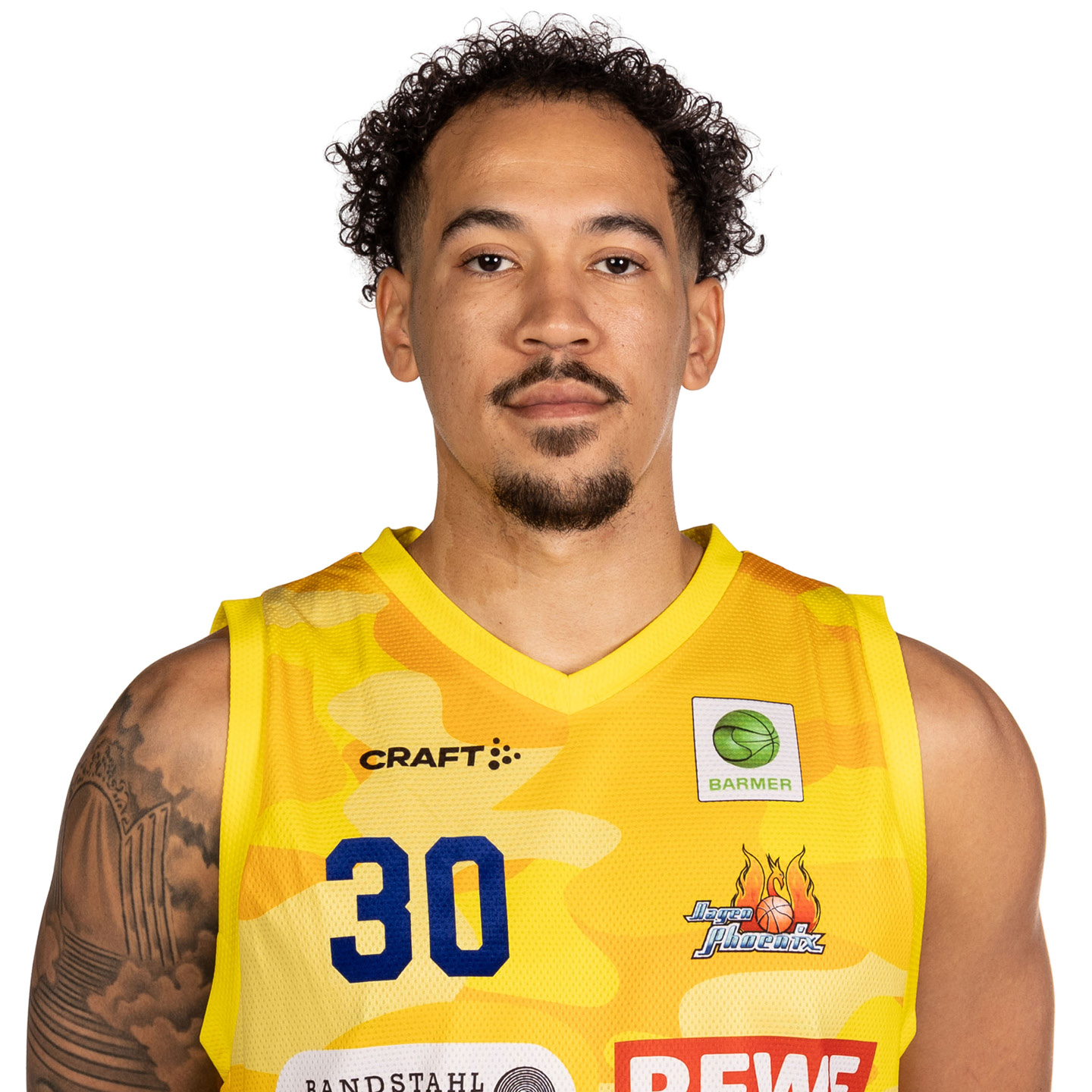 Ein Mann mit lockigem Haar in einem gelb gemusterten Basketballtrikot.