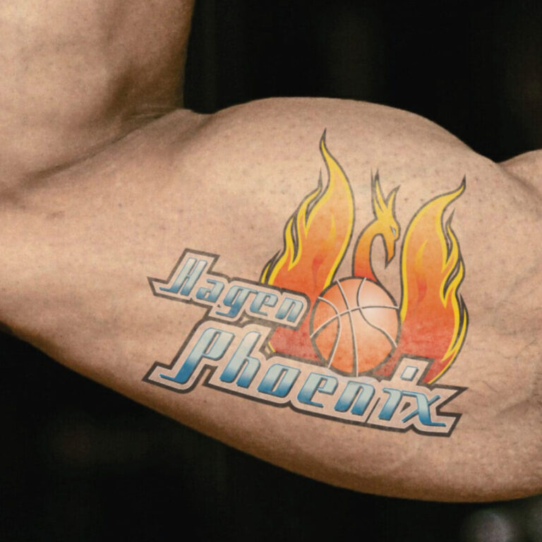 Ein muskulöser Arm zeigt ein Tattoo mit einem brennenden Phoenix und Basketball.