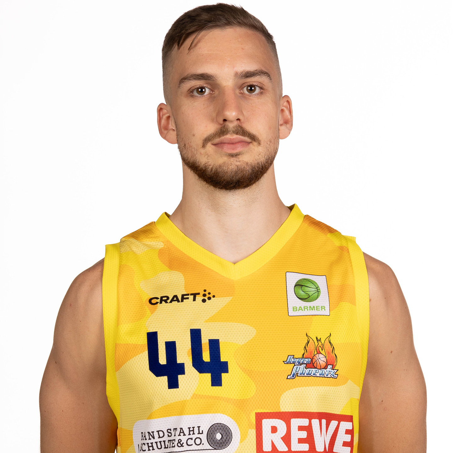 Ein Mann im gelben Basketballtrikot mit bestimmtem Ausdruck und Nummer 44