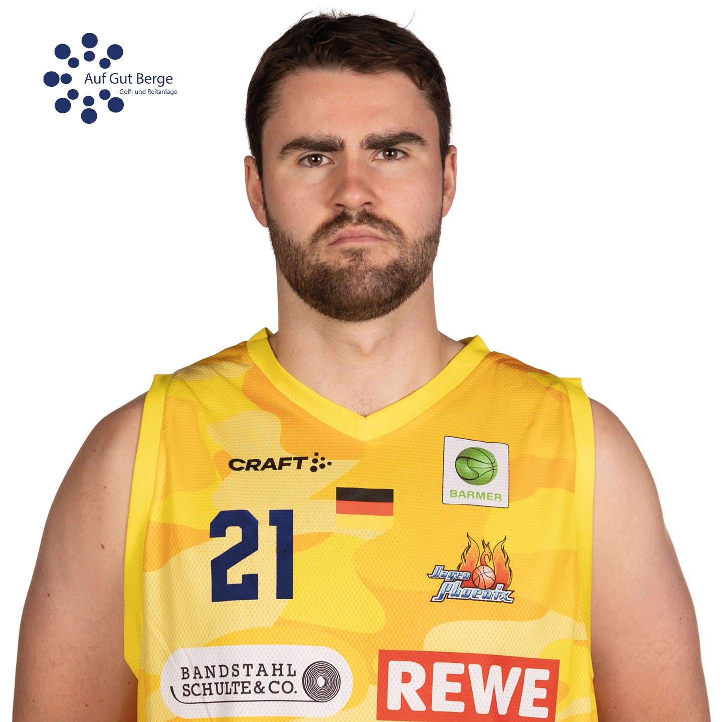 Basketballspieler mit entschlossenem Ausdruck im gelben Trikot mit Sponsorenlogos