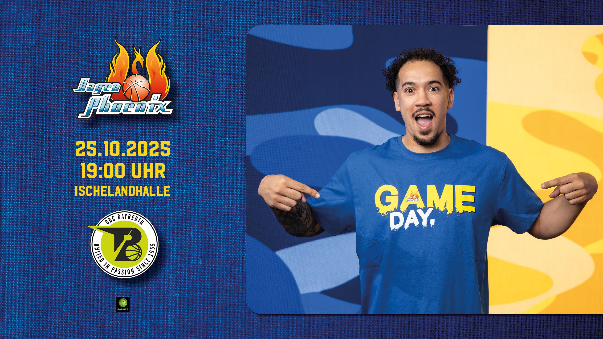 Ein lächelnder Mann zeigt auf sein blaues T-Shirt mit gelbem "GAME DAY"-Schriftzug.