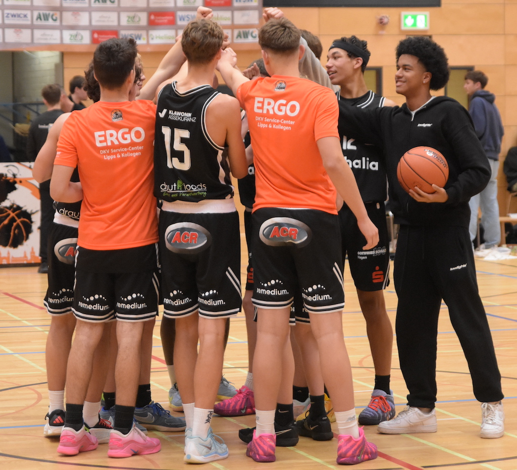 Eine Gruppe junger Basketballspieler im Kreis voller Vorfreude auf das bevorstehende Spiel