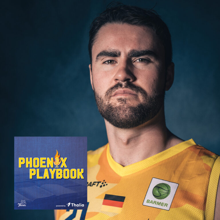 Ein junger Mann im gelben Basketballtrikot schaut ernst in die Kamera