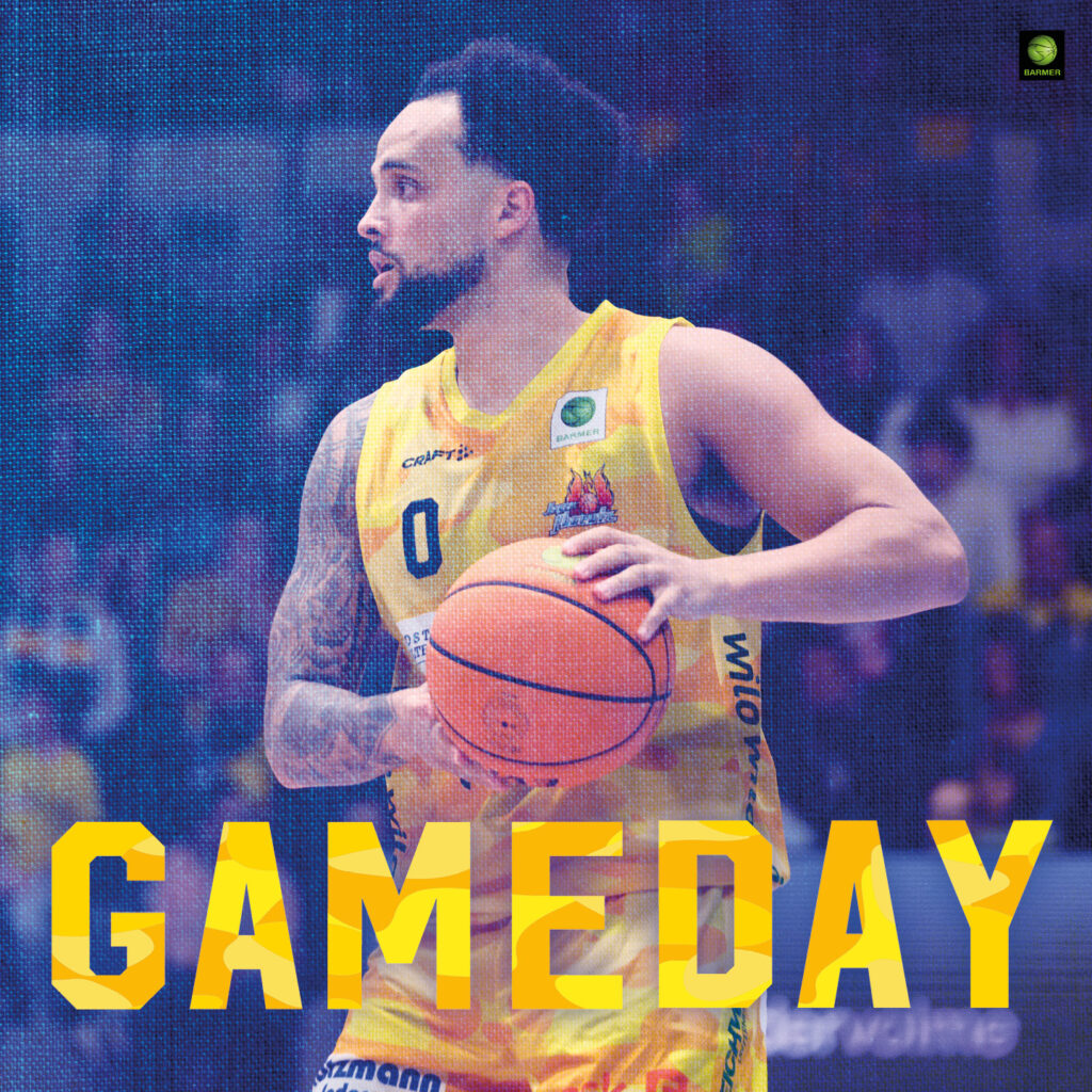 Ein Basketballspieler mit fokussiertem Blick im gelben Trikot hält den Ball bereit