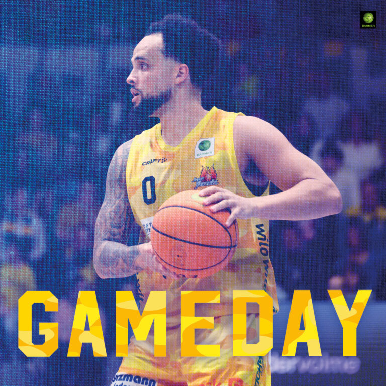 Ein Basketballspieler mit fokussiertem Blick im gelben Trikot hält den Ball bereit