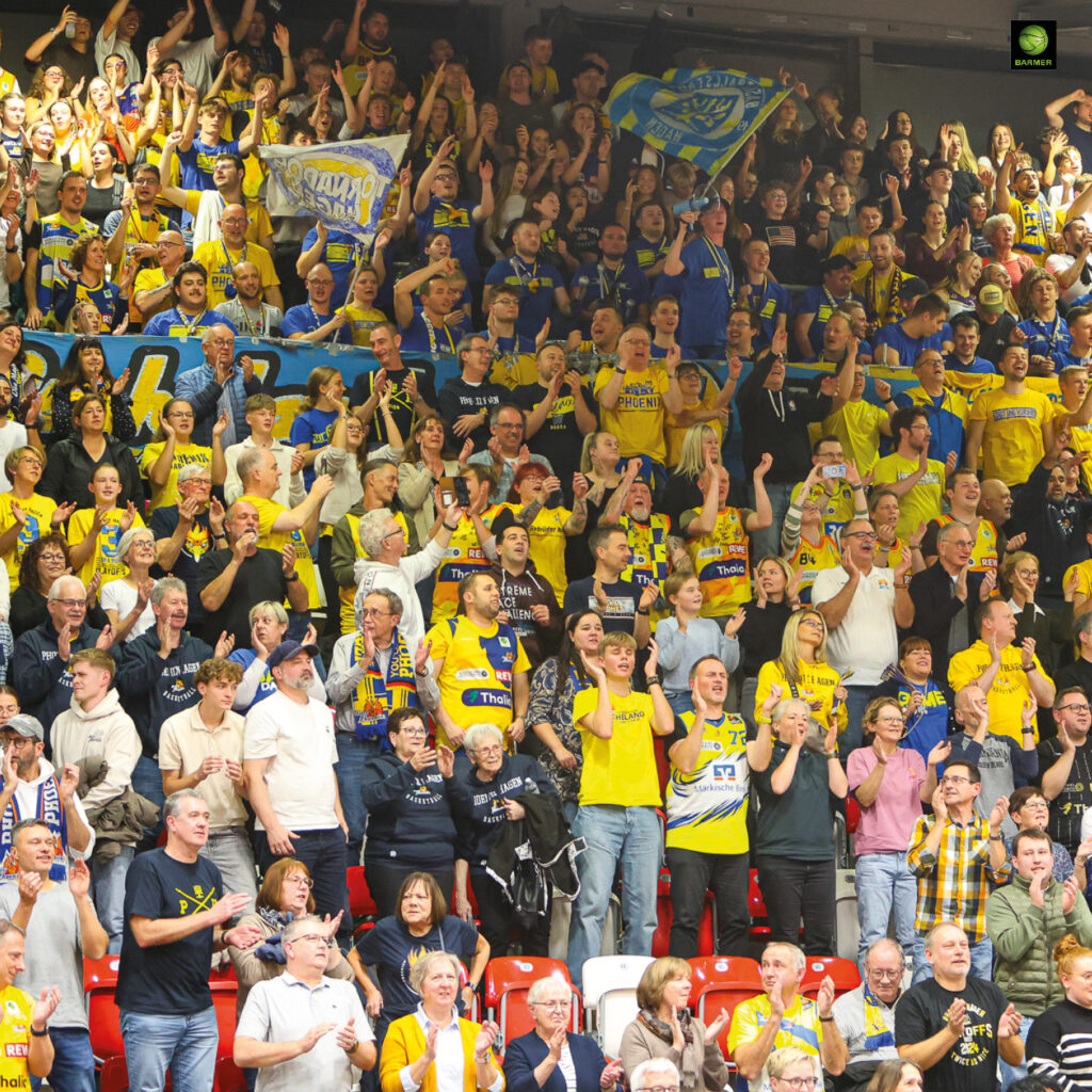 Viele jubelnde Fans in gelben und blauen Shirts feiern begeistert auf den Tribünen