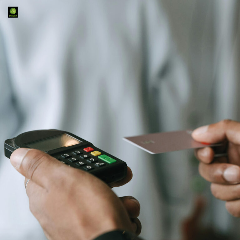 Eine Person hält eine rosa Karte an ein schwarzes Kartenlesegerät mit Tasten