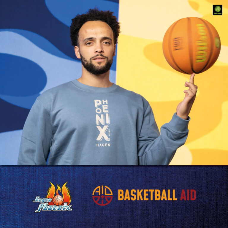 Ein junger Mann mit Bart lächelt leicht und balanciert einen Basketball auf dem Finger