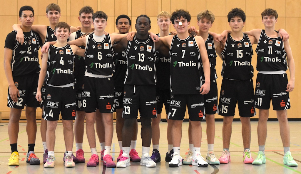 Eine fröhliche Basketballmannschaft in schwarzen Trikots posiert eng umschlungen