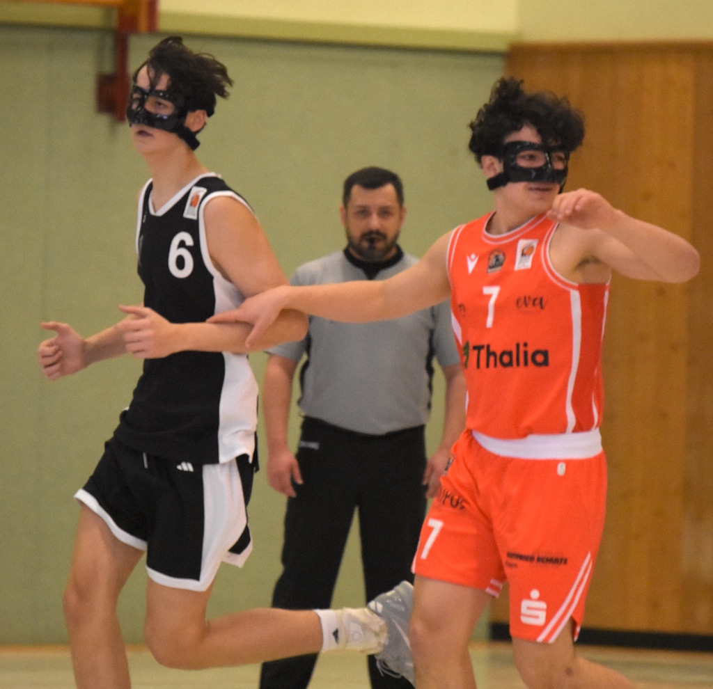 Zwei junge Basketballspieler mit schwarzen Masken im sportlichen Wettkampf, entschieden