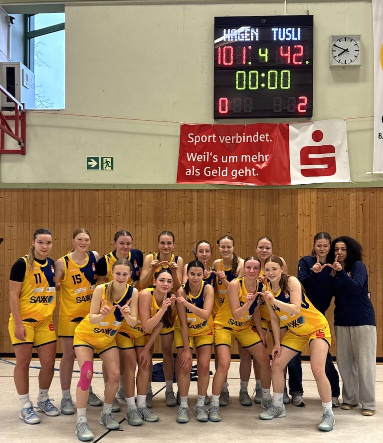 Eine Frauen Basketballmannschaft in gelben Trikots feiert jubelnd einen Sieg