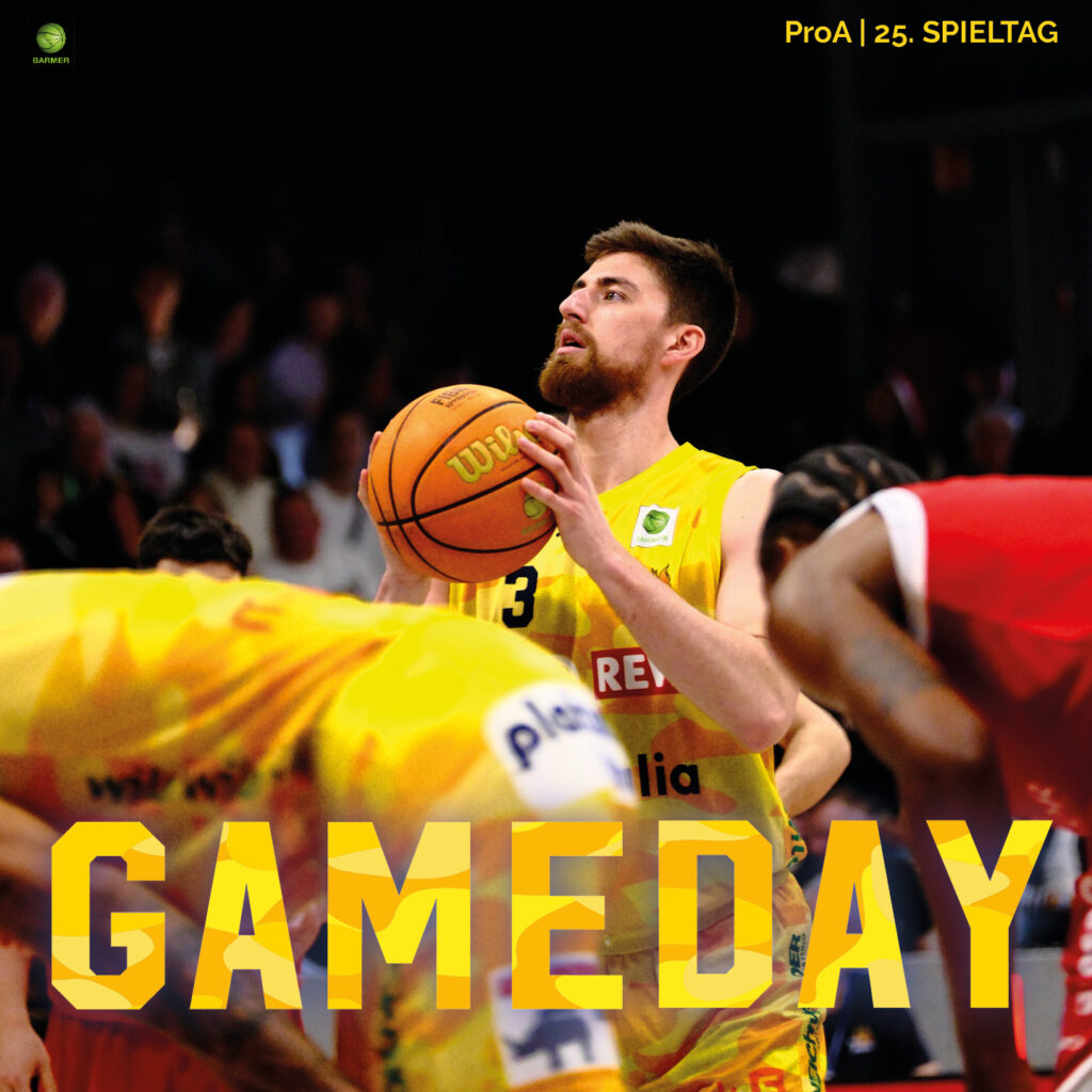 Ein bärtiger Basketballspieler im gelben Trikot schaut konzentriert nach oben