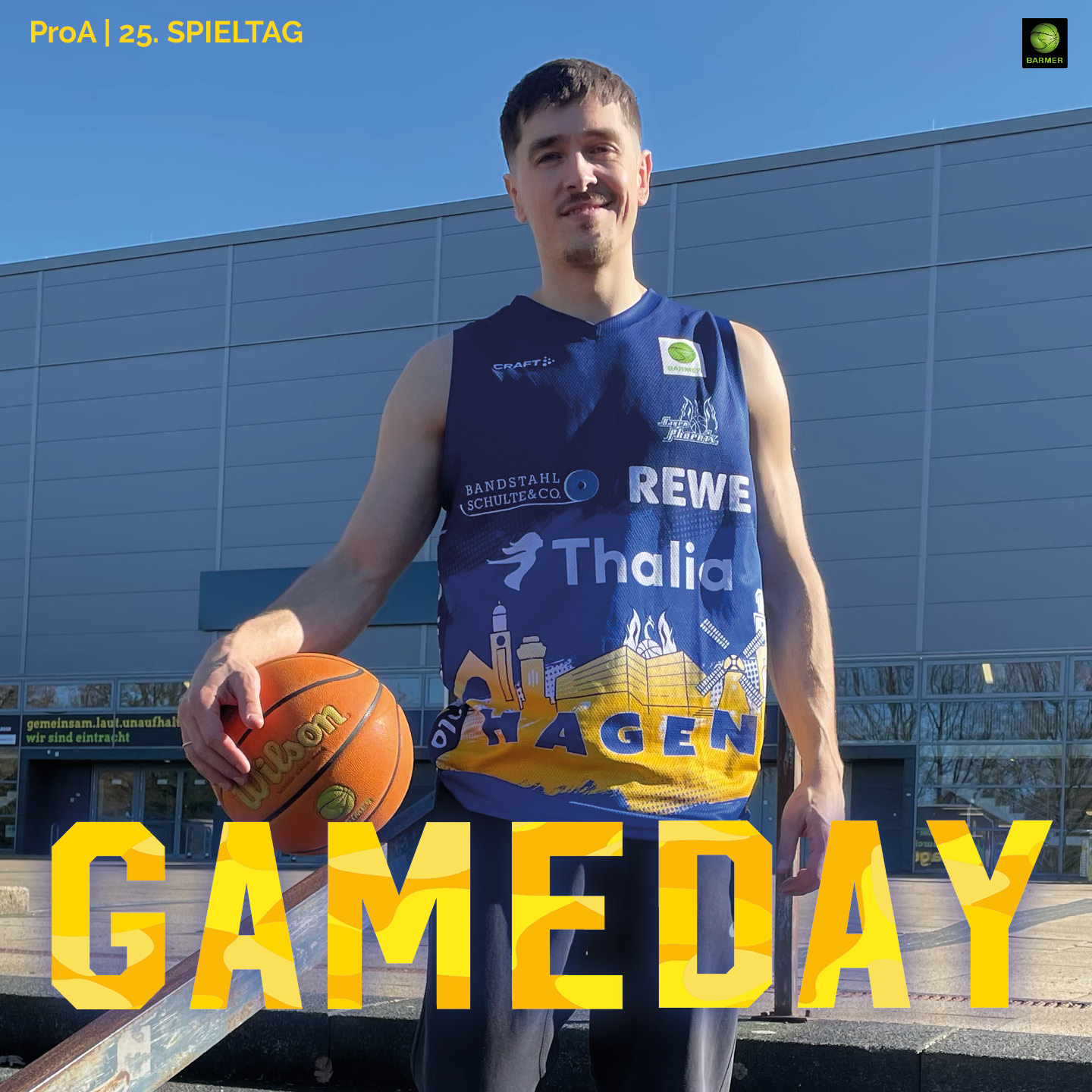 Ein junger Mann mit kurzem braunem Haar lächelt leicht, trägt ein blau-gelbes Basketballtrikot und hält einen Basketball in der Sonne