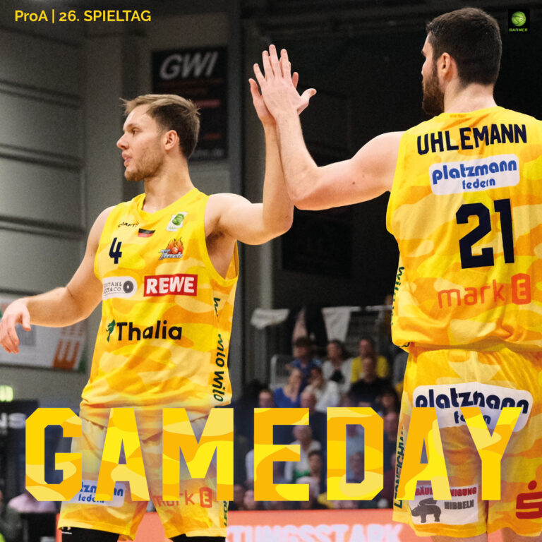 Zwei Basketballspieler im gelben Trikot mit ernsten Gesichtern beim Abklatschen