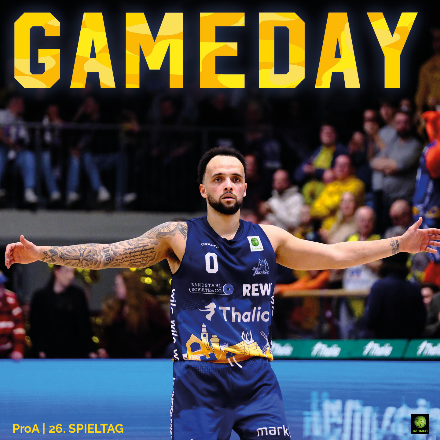 Ein Basketballspieler in dunkelblauem Trikot steht mit ausgebreiteten Armen auf dem Spielfeld