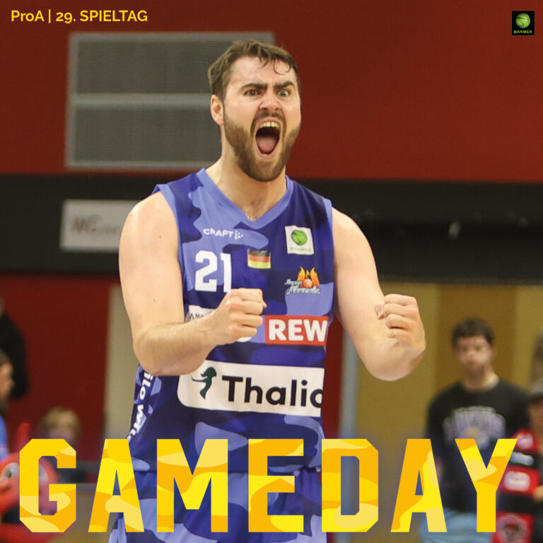 Ein Basketballspieler im blauen Trikot jubelt mit entschlossenem Gesichtsausdruck