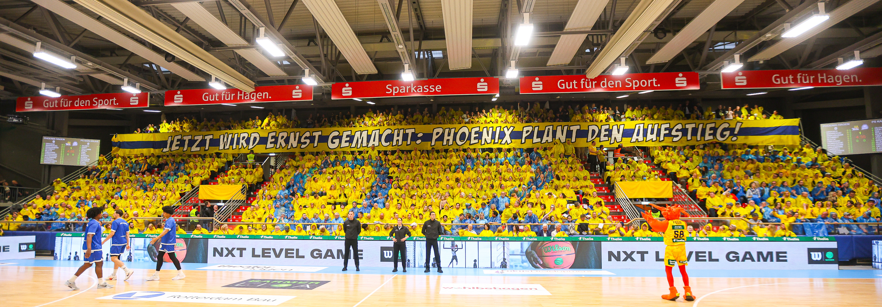 Viele Fans in Gelb und Blau jubeln laut in einer farbenfrohen Basketballarena