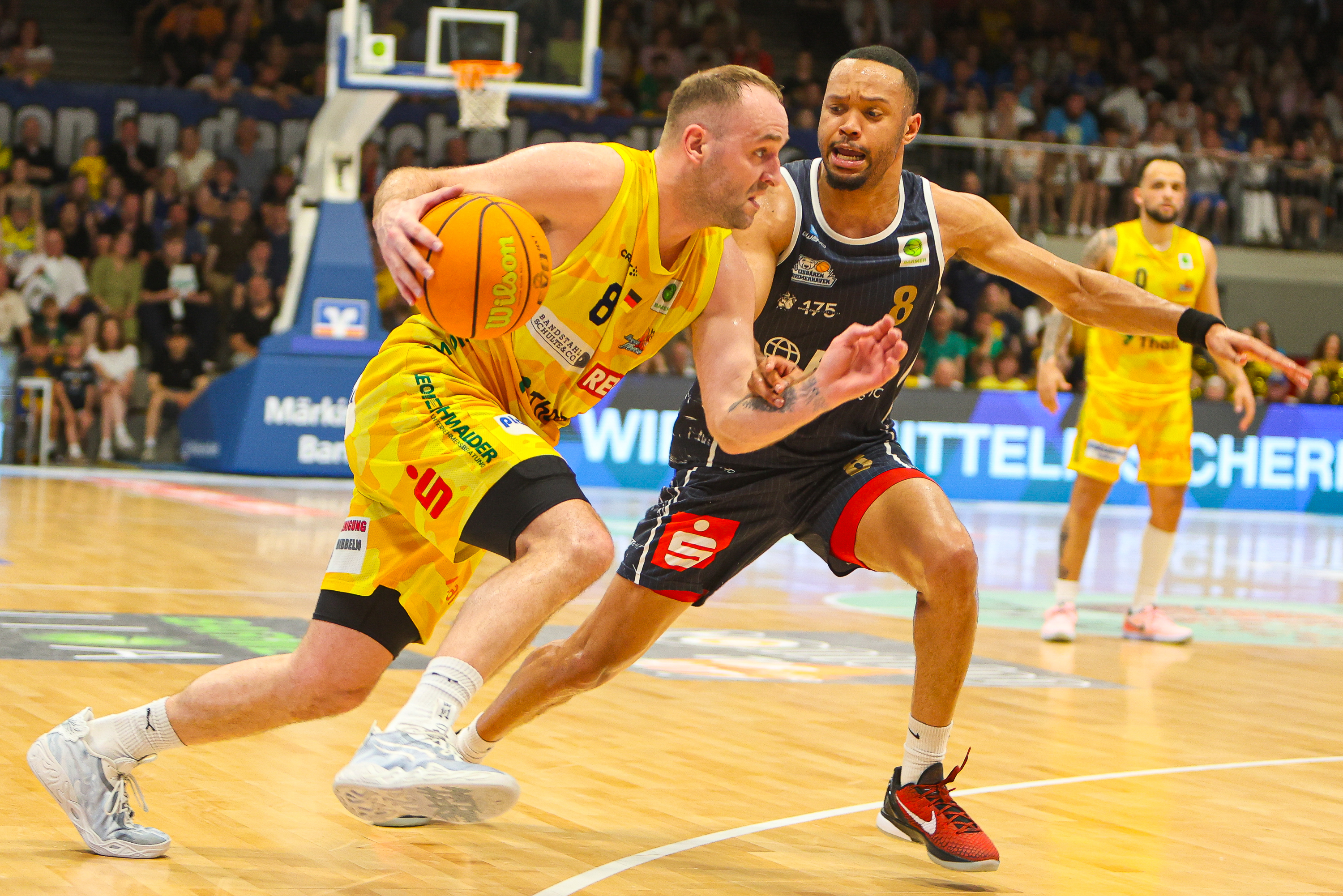 Zwei Basketballspieler konzentriert gelb gegen schwarz orange Ball schnelle Aktion