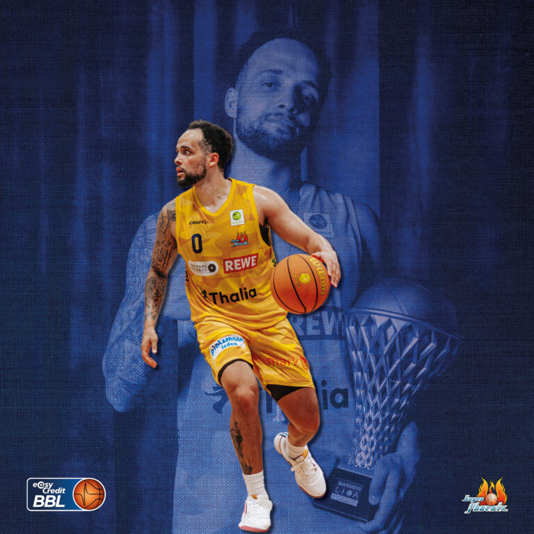 Fokussierter Basketballspieler im gelben Trikot mit Ball vor blauem Portraet