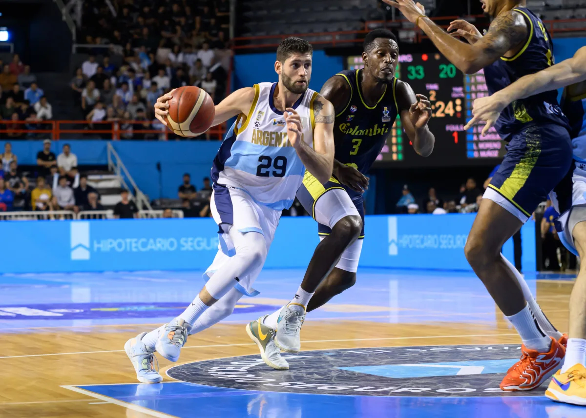Konzentrierter Basketballspieler im weissen Argentinien-Trikot dribbelt am Gegner vorbei