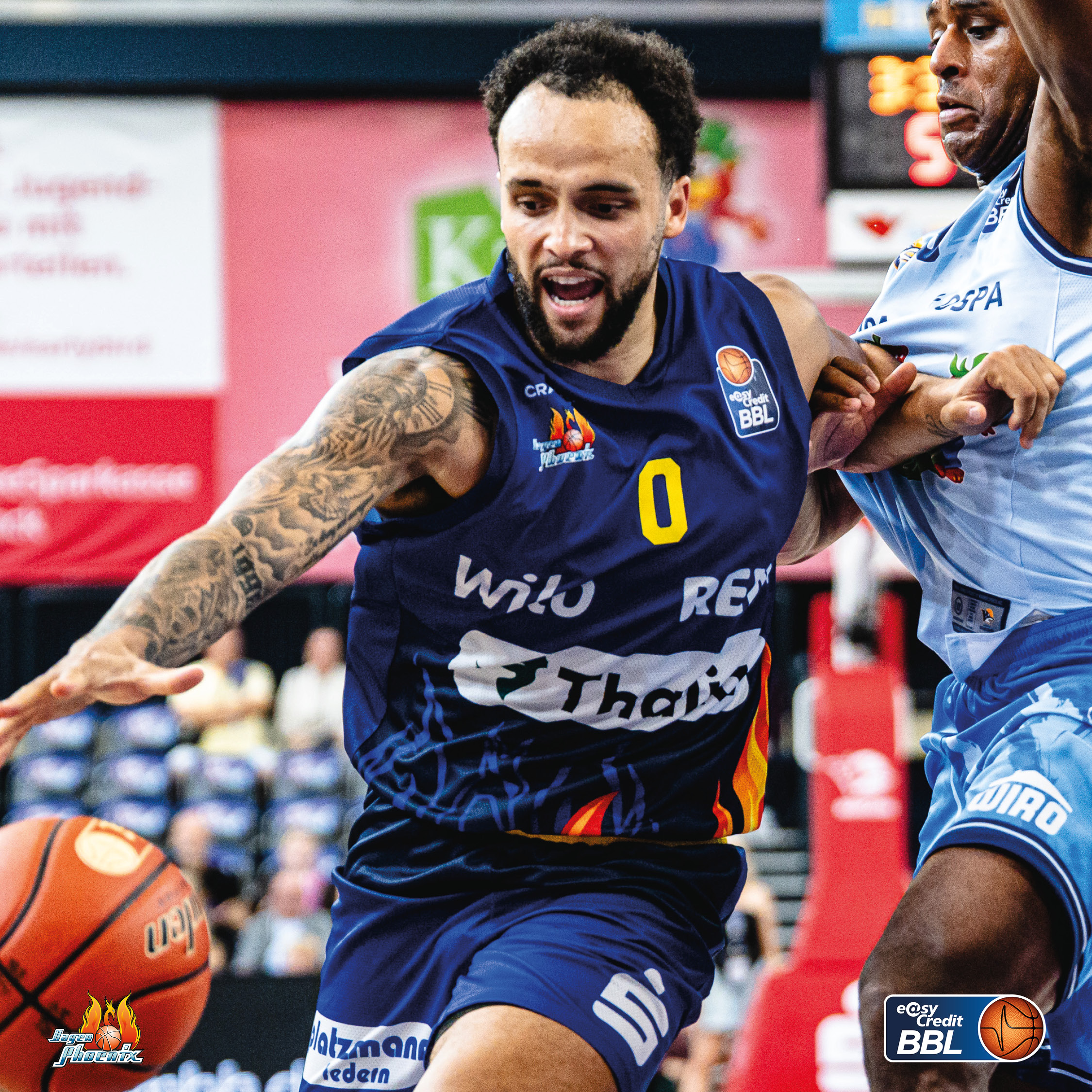 Basketballspieler mit blauem Trikot und Tattoos dribbelt konzentriert am Gegner vorbei