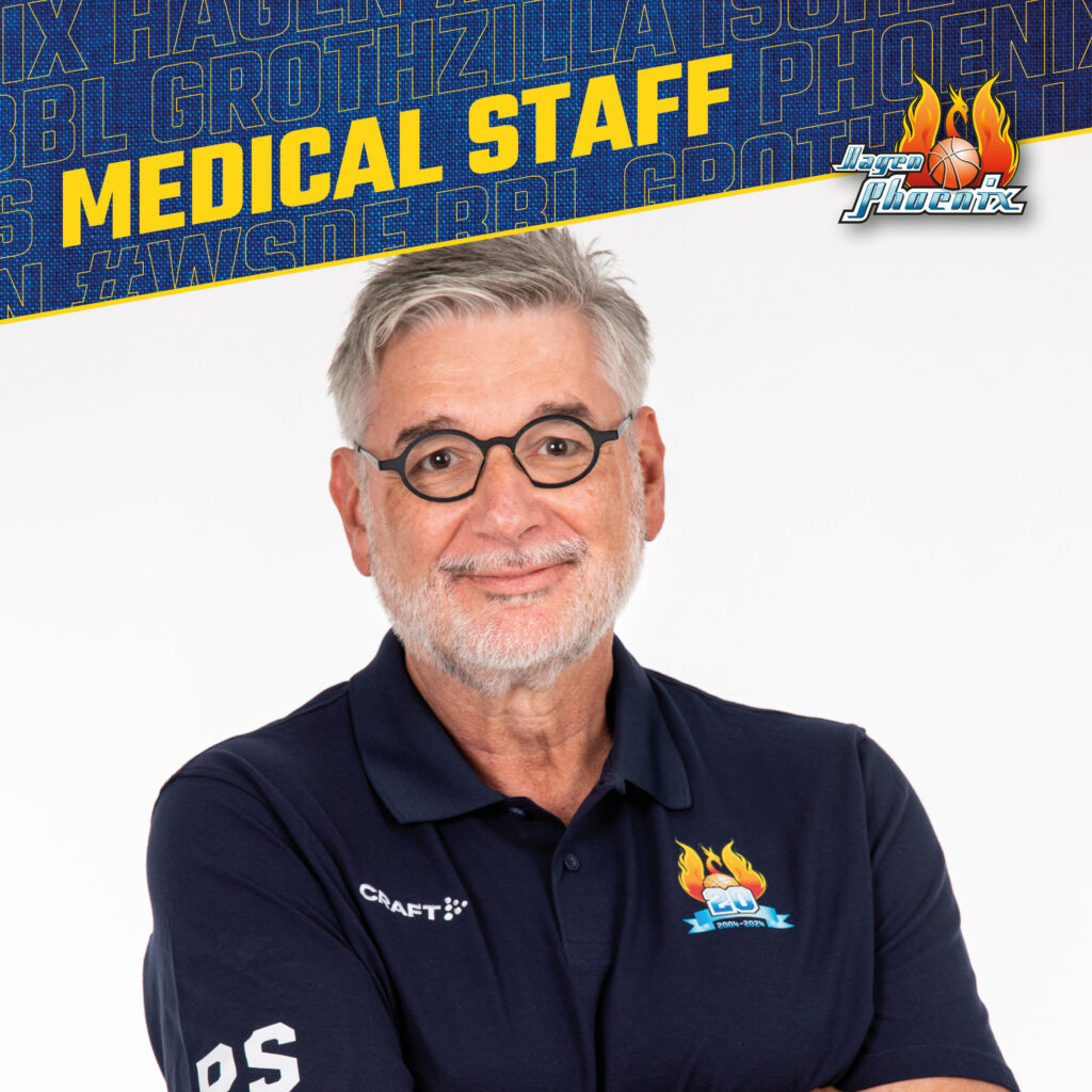 Laechelnder Mann mit grauem Bart und Brille im dunkelblauen Phoenix Poloshirt