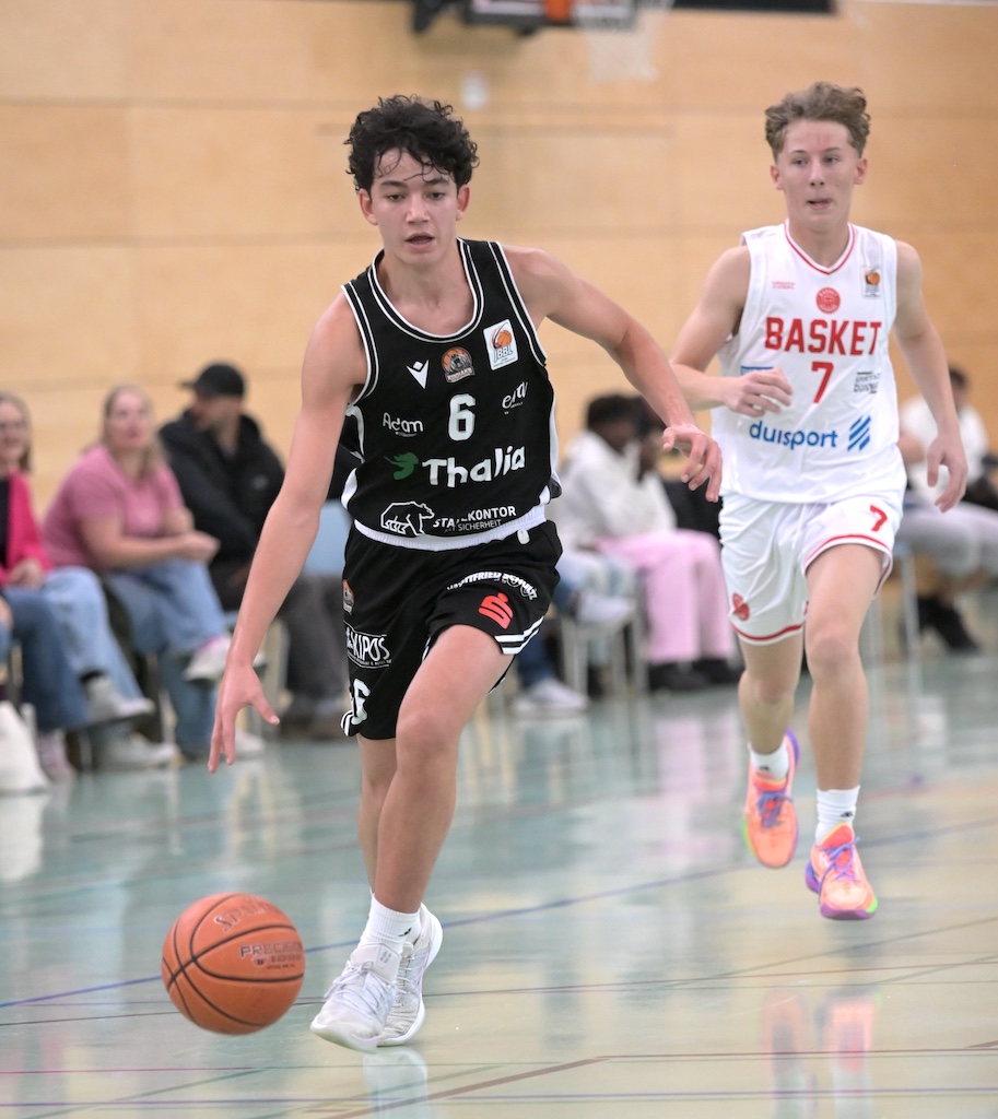 Zwei junge Basketballspieler in schwarzem und weissem Trikot beim Spiel