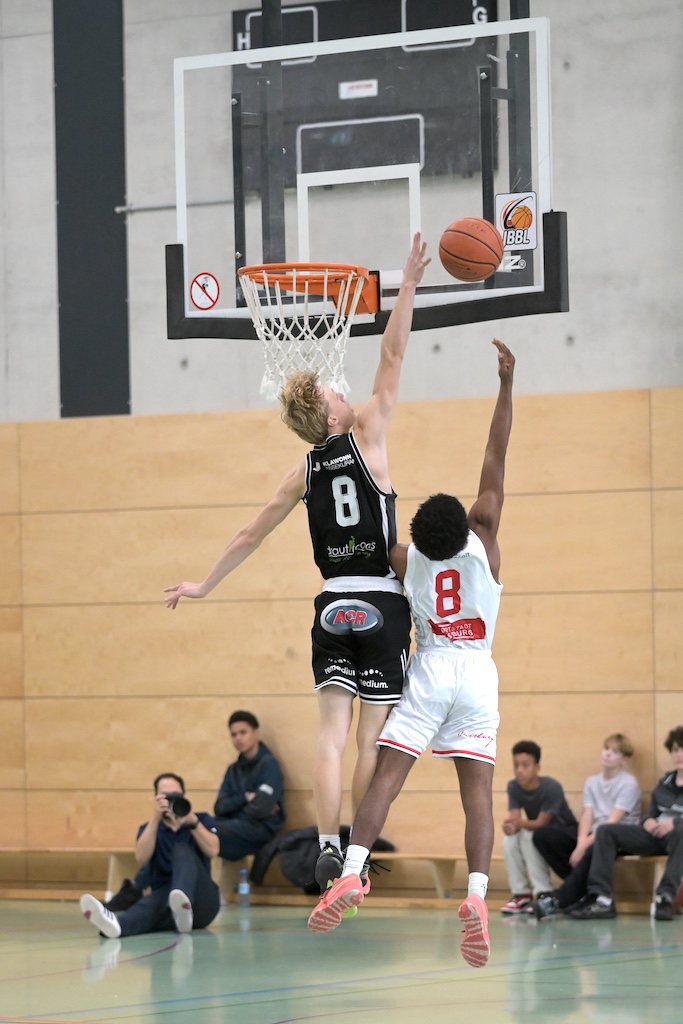 Zwei Basketballspieler mit Nummer 8 springen konzentriert zum Korb hoch