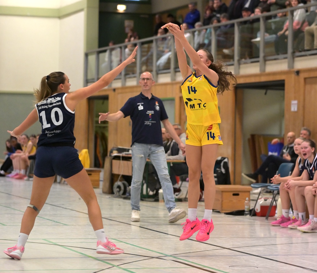 Basketballspielerin in gelbem Trikot Nummer 14 springt zum Wurf