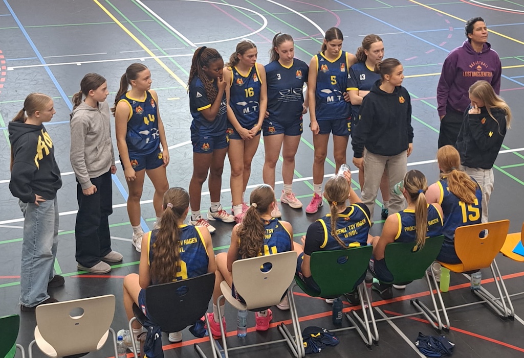 Ein Basketballteam in blau gelben Trikots versammelt sich in der Halle